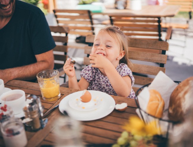 Fröhliches Kind beim Essen im Freien im Obersulzberggut in Radstadt © Lorenz Masser Fotografie