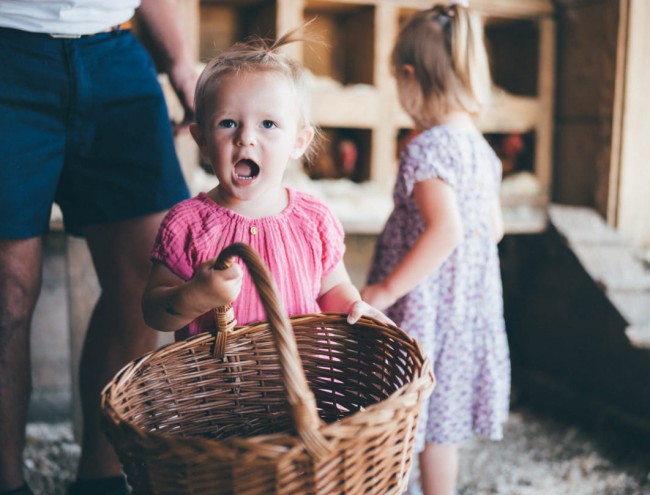 Kleines Kind trägt einen Korb mit frischen Eiern im Hühnerstall des Obersulzbergguts in Radstadt © Lorenz Masser Fotografie