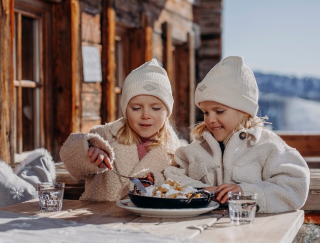 Zwei Mädchen genießen einen leckeren Kaiserschmarrn © SalzburgerLand Tourismus