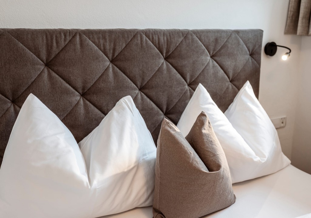 Gemütliches Kopfkissen-Arrangement im Schlafzimmer auf dem Bauernhof Obersulzberggut in Radstadt © Lorenz Masser Fotografie