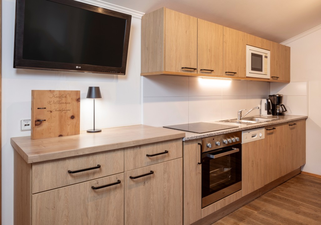 Modern kitchen with wooden cabinets and appliances at Obersulzberggut farm in Radstadt © Lorenz Masser Photography