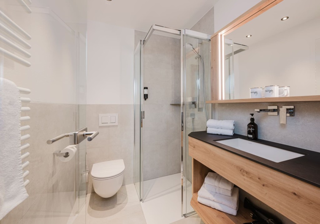 Modernes Badezimmer mit Dusche und Holzelementen auf dem Bauernhof Obersulzberggut in Radstadt © Lorenz Masser Fotografie