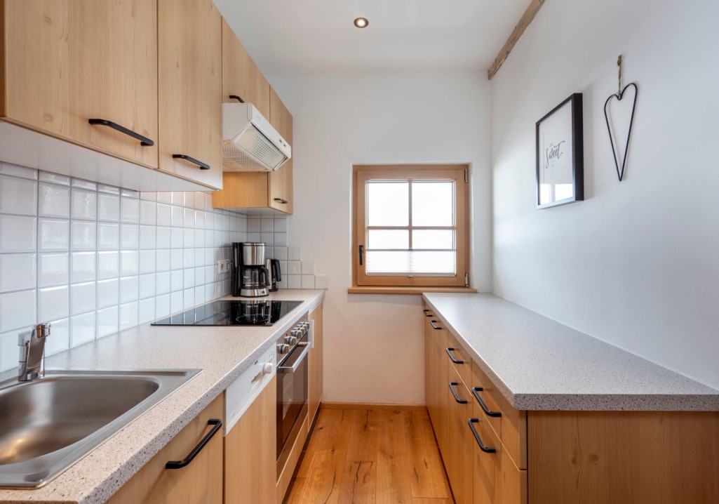 Moderne Küche mit Holzarbeitsplatten und weißen Fliesen auf dem Bauernhof Obersulzberggut in Salzburg © Lorenz Masser Fotografie