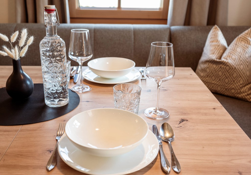 Set table with water bottle and dishes at Obersulzberggut farm in Radstadt © Lorenz Masser Photography