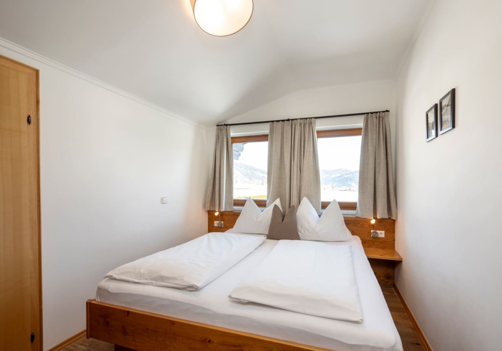 Second bedroom with double bed and wooden beams at Obersulzberggut in Radstadt © Lorenz Masser Photography